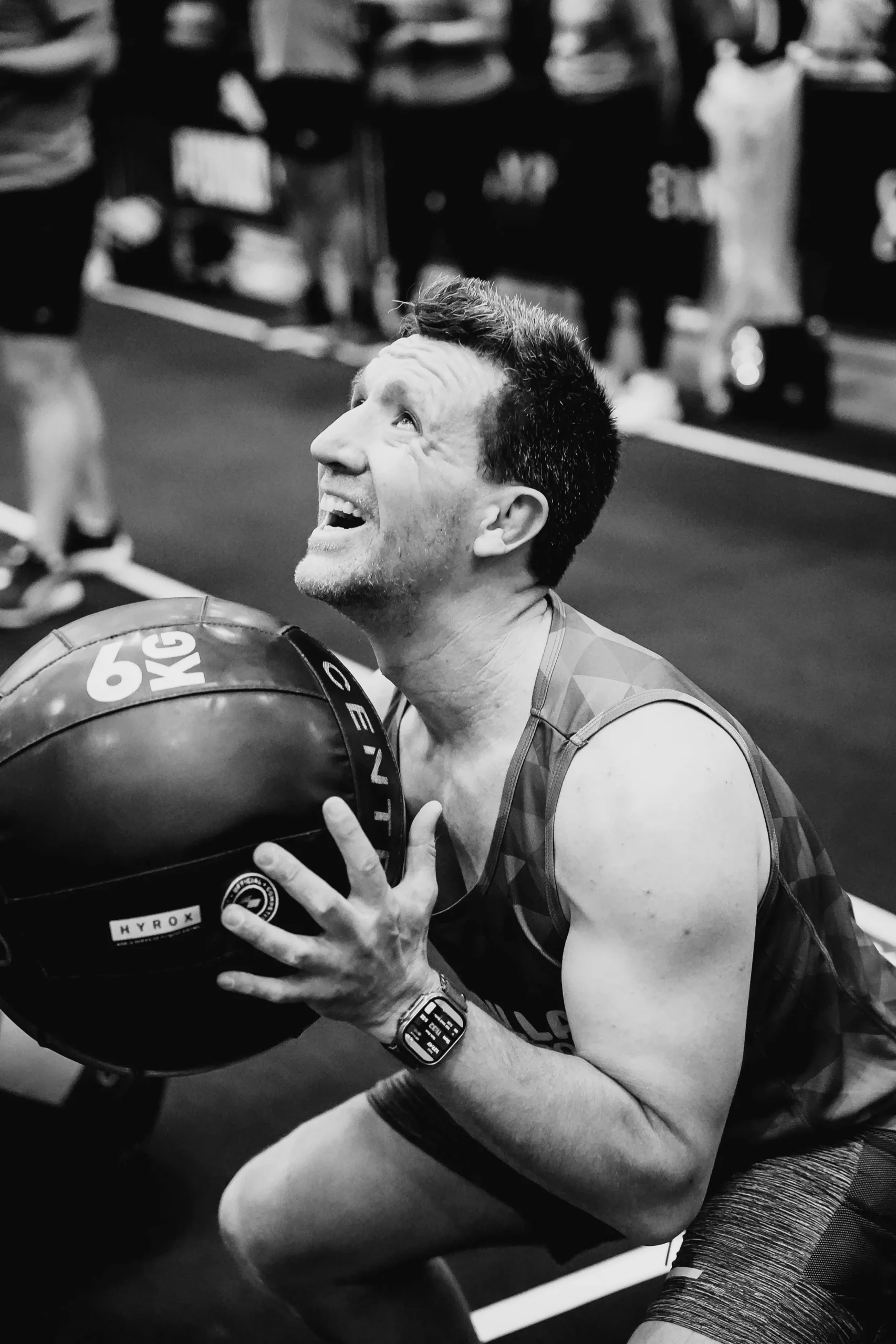 Man squats holding 6kg Wall ball at HYROX Event